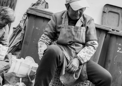 Elderly men and women sitting quietly by the roadside