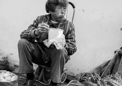 Elderly men and women sitting quietly by the roadside
