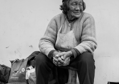 Elderly men and women sitting quietly by the roadside